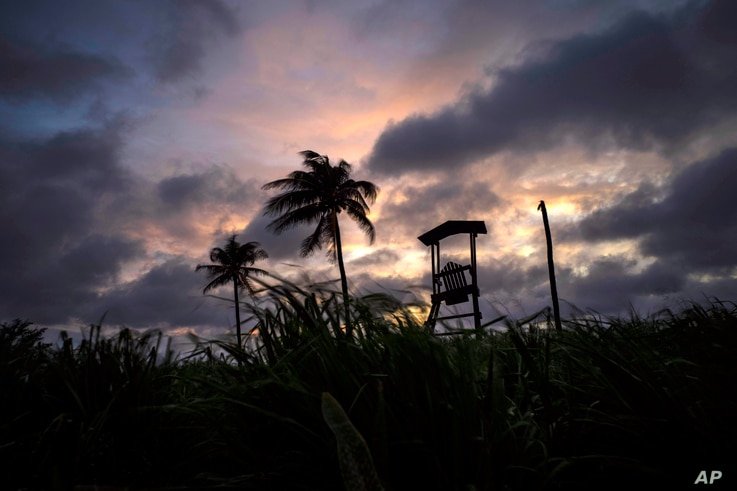 Wind moves the grass and palm trees under a cloudy sky after the passage of Tropical Storm Elsa in Havana, Cuba, Monday, July 5…