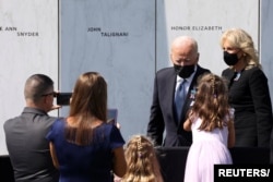 El presidente de EE. UU., Joe Biden, junto a la primera dama Jill Biden, extiende una mano a una niña entre la multitud durante una visita al National Memorial en Stoystown, Pennsylvania, EE. UU., 11 de septiembre de 2021.