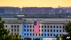Una bandera estadounidense es desplegada en la sede del Pentágono, en la mañana del 20 aniversario de los ataques terroristas del 11 de septiembre.
