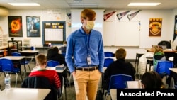 ARCHIVO - Un maestra sustituto en la Escuela Intermedia Greenfield en Greenfield, Indiana, enseña el 10 de diciembre de 2020.