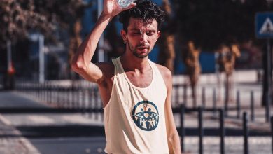 tired sportsman pouring water on head after running training